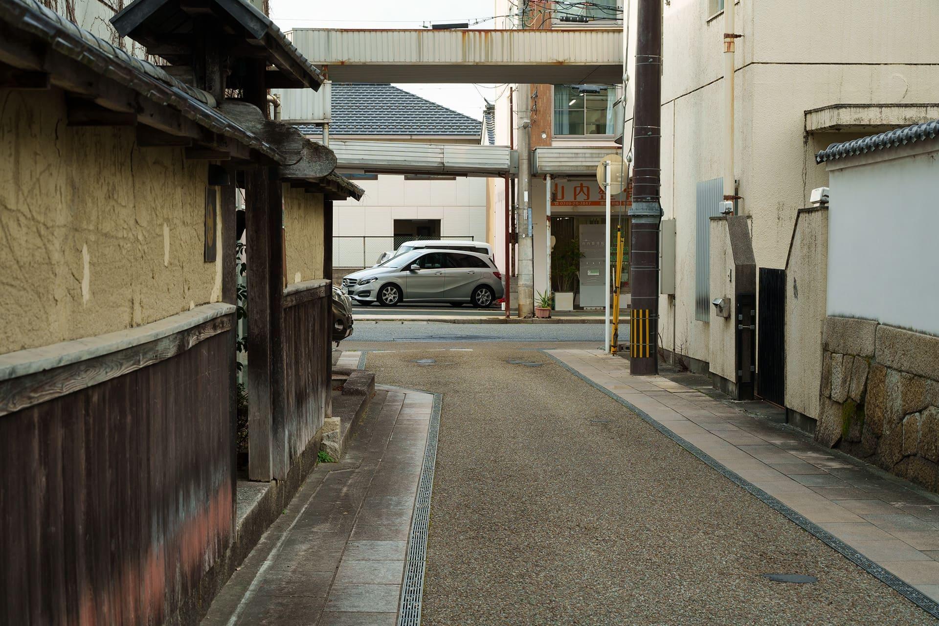 上の写真（1957年ごろ）の路地の現在の様子（2026年1月）。左の土壁に面影がはっきりと残る。